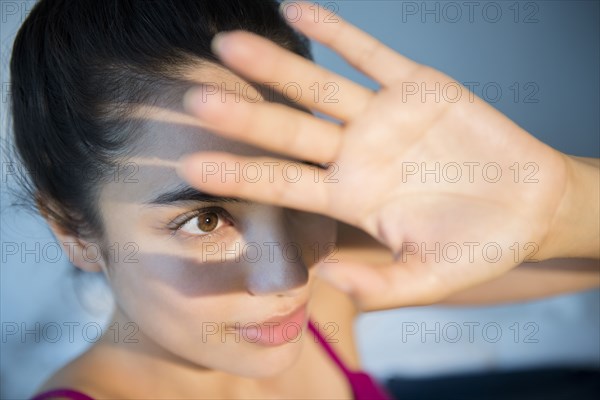 Hispanic woman shielding herself from light