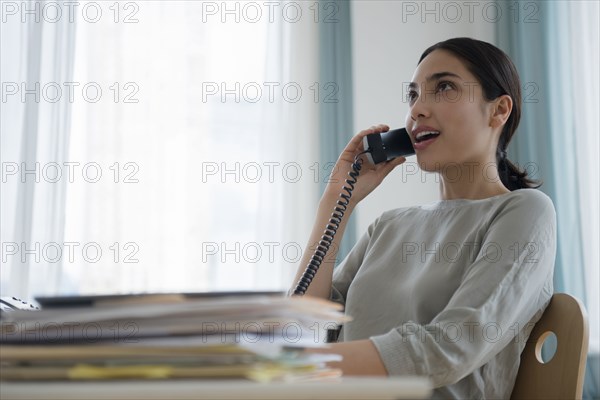 Hispanic businesswoman talking on telephone