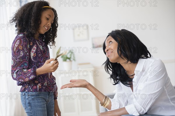 Daughter paying mother in living room