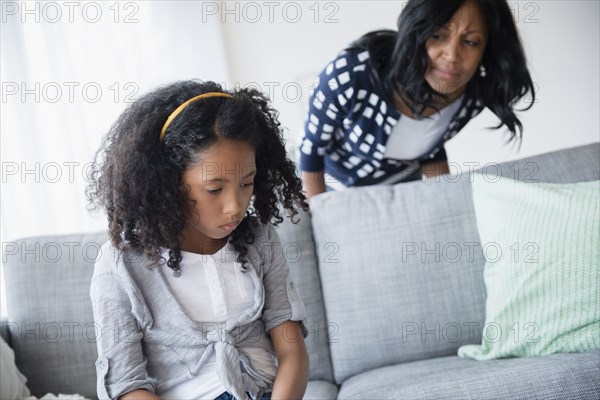 Mother watching sulking daughter