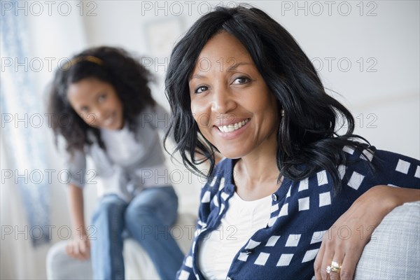 Mother and daughter smiling on sofa