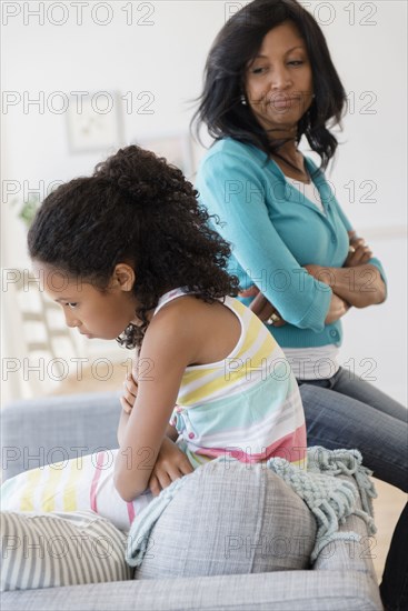 Mother and daughter arguing on sofa