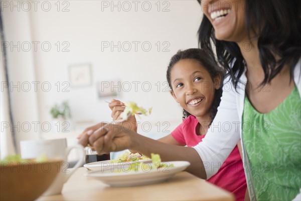 Mother and daughter eating salad