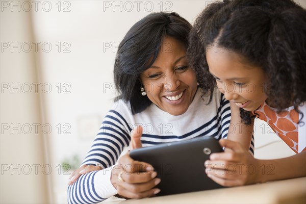 Mother and daughter using digital tablet