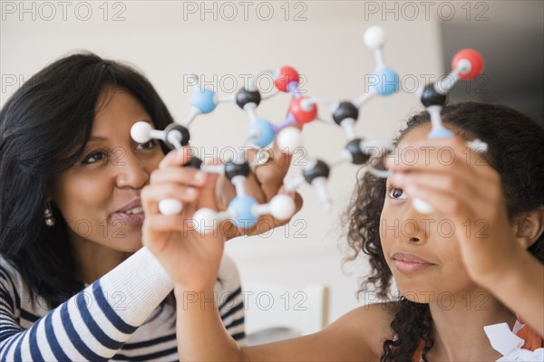 Mother and daughter examining molecular model