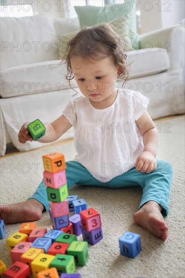 Mixed race baby girl playing with blocks