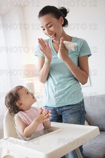 Mother clapping with baby daughter
