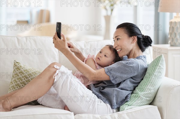 Mother taking selfie with baby daughter