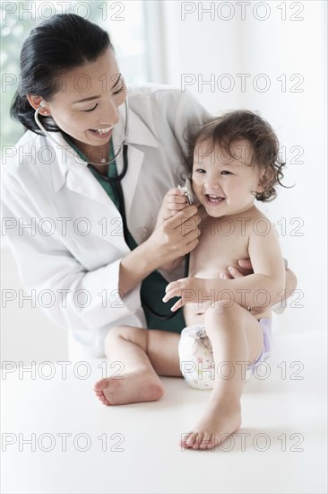 Doctor and baby girl playing with stethoscope