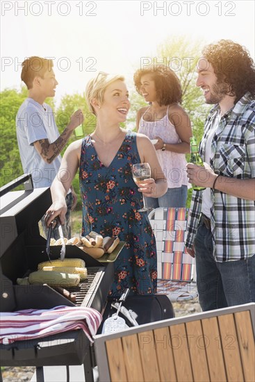 Woman serving hot dogs at barbecue