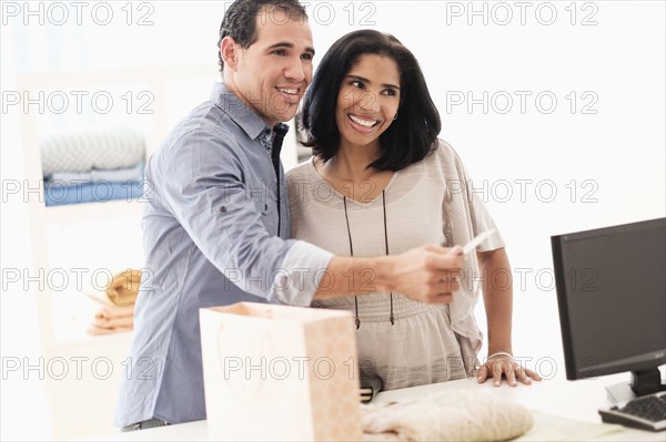 Hispanic couple paying at register