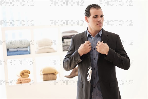 Hispanic man trying on suit in store