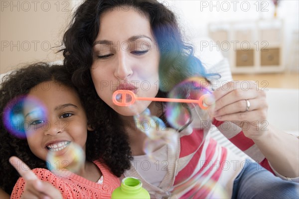 Mother and daughter blowing bubbles