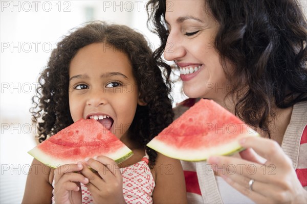 Mother and daughter eating watermelon