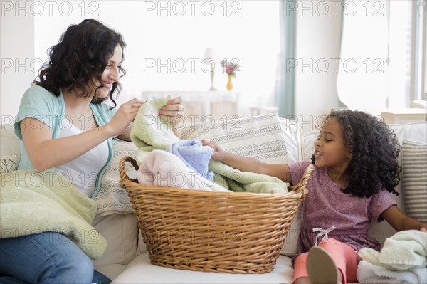 Mother and daughter folding laundry