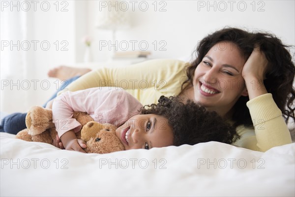 Mother and daughter smiling on bed