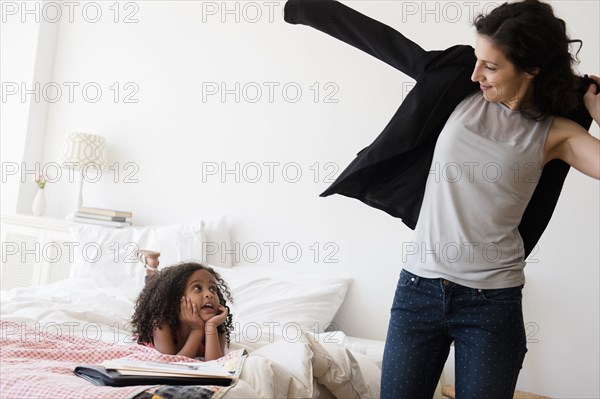 Mother and daughter getting ready in bedroom