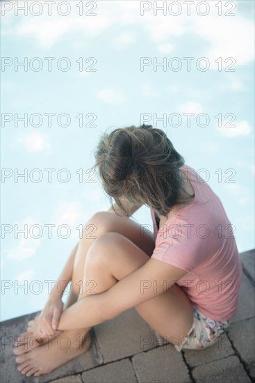 Caucasian woman sitting at swimming pool