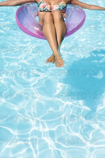 Caucasian woman floating in swimming pool