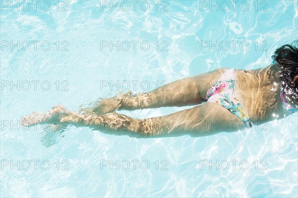 Caucasian woman swimming in pool