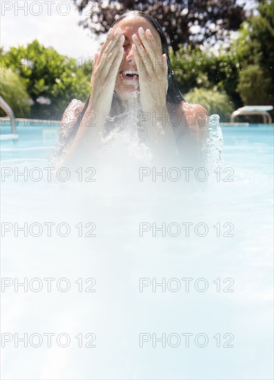 Caucasian woman laughing in swimming pool