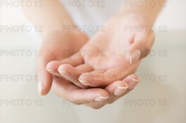 Close up of cupped hands of Hispanic woman