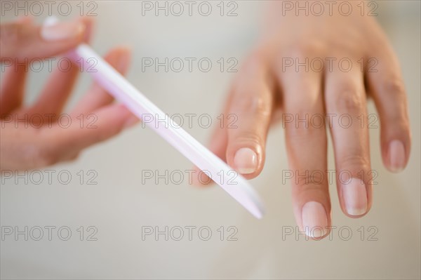 Close up of Hispanic woman filing her nails