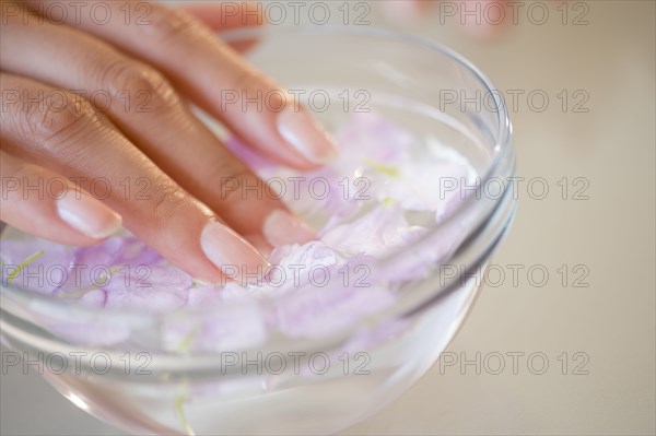 Close up of Hispanic woman soaking her nails
