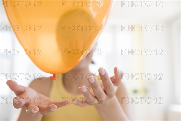 Hispanic woman playing with balloon
