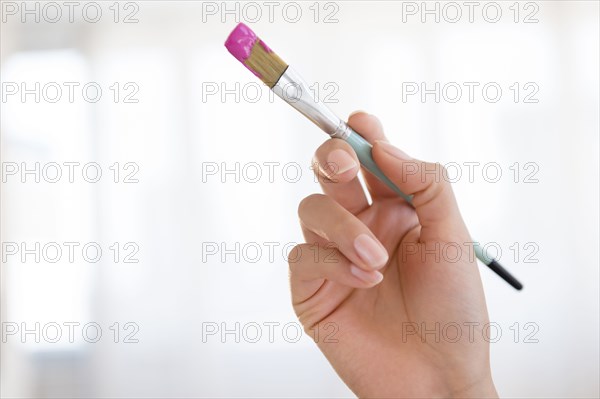 Hispanic woman holding paintbrush