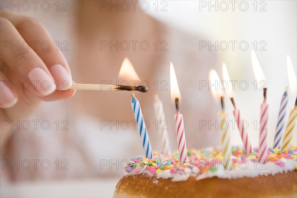 Hispanic woman lighting birthday candles