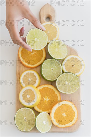 Hispanic woman holding sliced lime