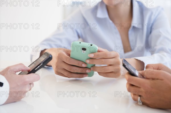 Business people using cell phones in office