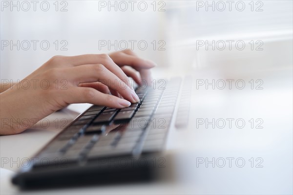 Hispanic businesswoman typing on keyboard