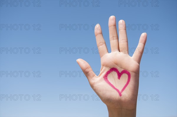 Hispanic woman with heart on hand