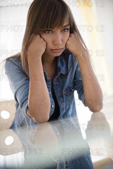 Mixed race woman pouting at table