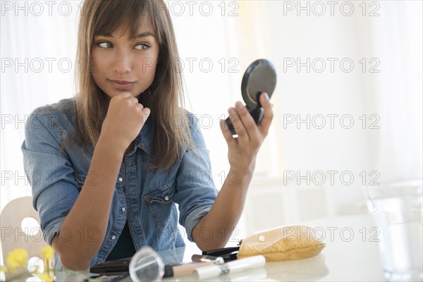 Mixed race woman admiring herself in mirror