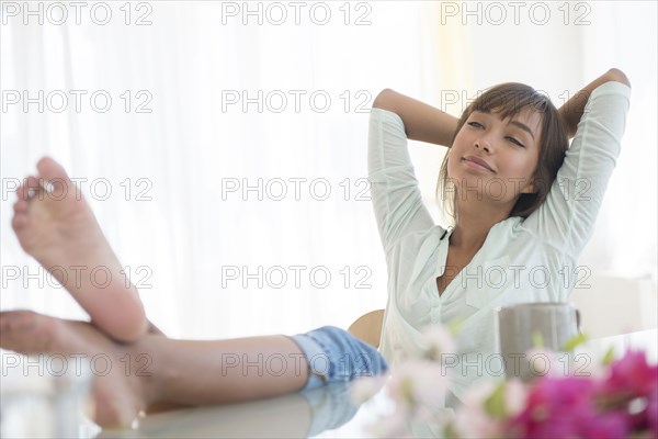 Barefoot mixed race woman relaxing