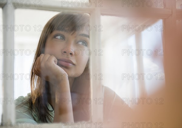 Mixed race woman looking out window
