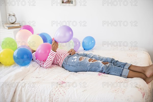 Mixed race woman playing with balloons