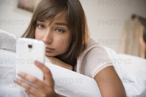 Mixed race woman using cell phone