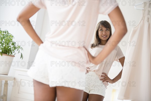 Mixed race woman looking in mirror