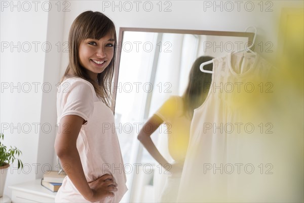 Mixed race woman smiling in front of mirror