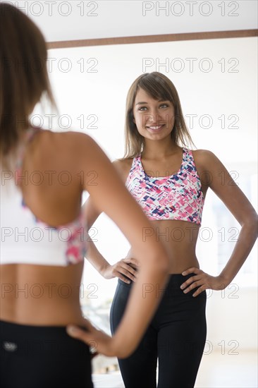 Mixed race woman looking in mirror