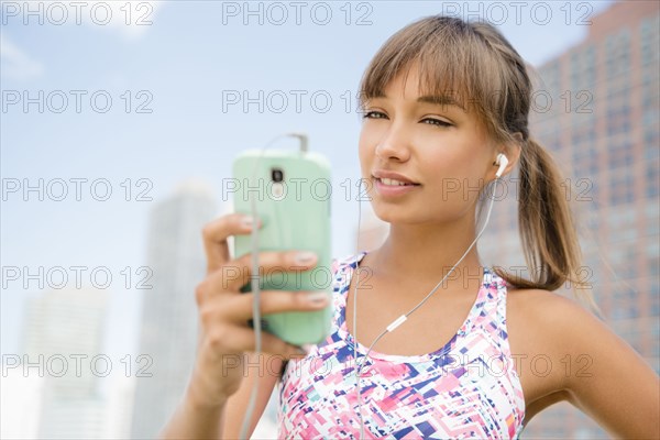 Mixed race woman listening to earbuds