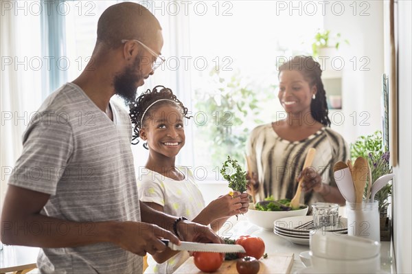 Black family cooking in kitchen