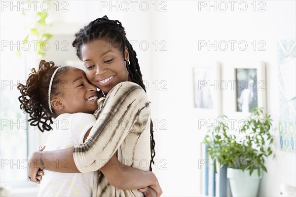 Black mother and daughter hugging
