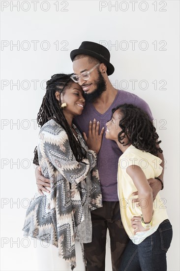 Smiling Black family hugging