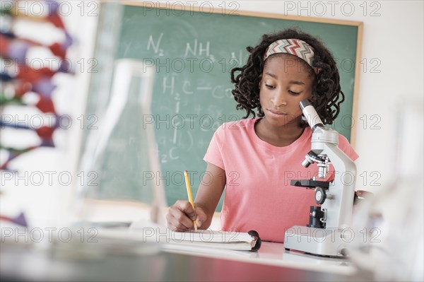 Black student performing experiment in science class