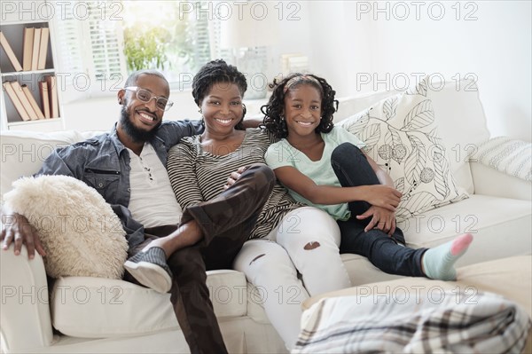 Black family smiling on sofa